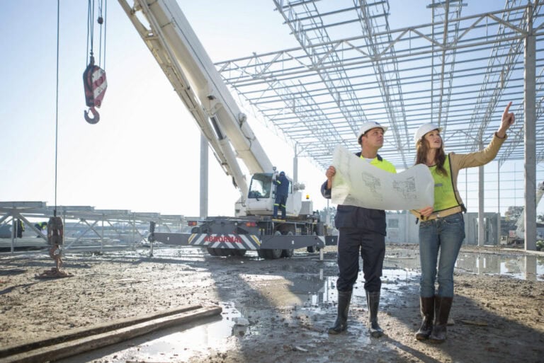 Site Engineer and Architect checking blueprint on site